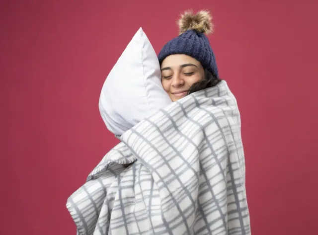 winter, sleep apnea, young woman wearing winter scarf hugging pillow