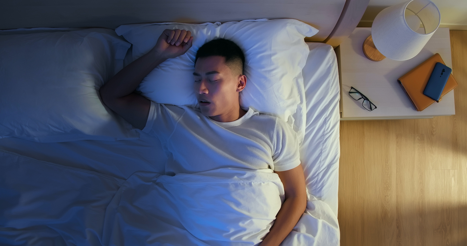 Aerial view of an Asian man sleeping with his mouth open due to sleep apnea