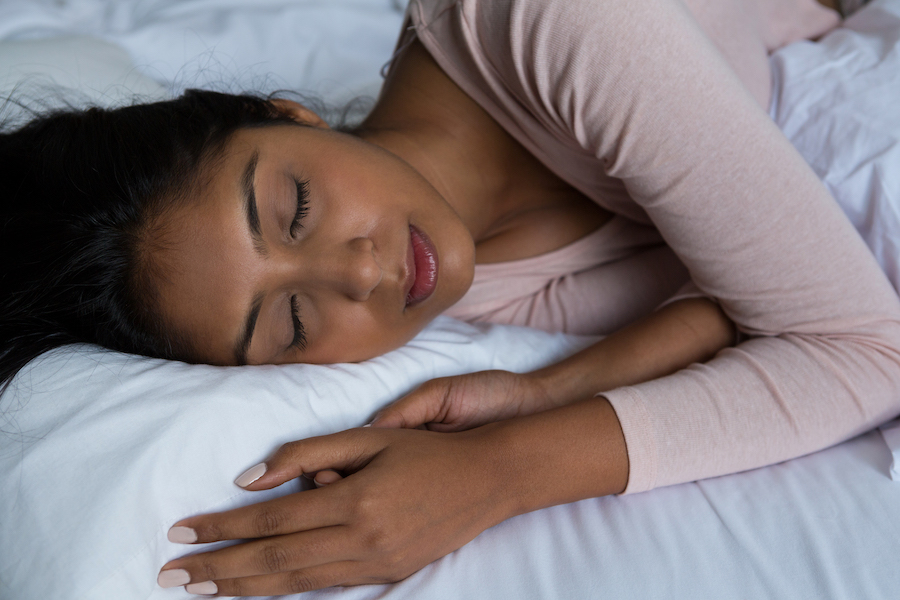 Black woman sleeping soundly in her bed, experiencing REM sleep