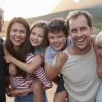 A multigenerational family with 2 children, 2 parents, and 2 grandparents outside