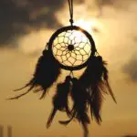 Dreamcatcher silhouette against a cloudy sky