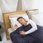 Photograph of woman sleeping with a weighted blanket.