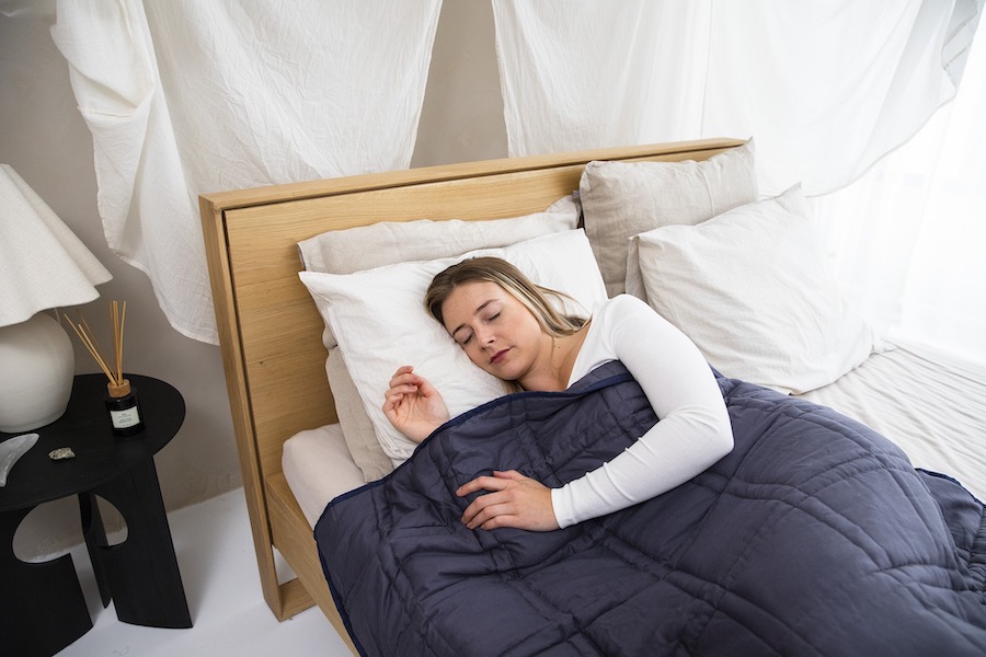 Photograph of woman sleeping with a weighted blanket.