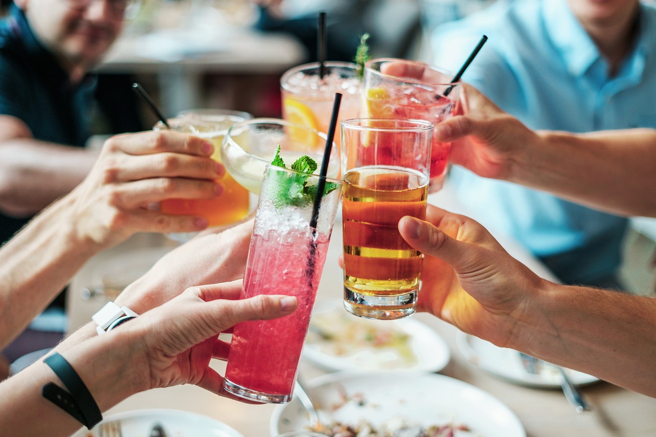 Photograph of group of people doing cheers with various alcoholic drinks, alcohol and sleep