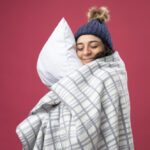 winter, sleep apnea, young woman wearing winter scarf hugging pillow